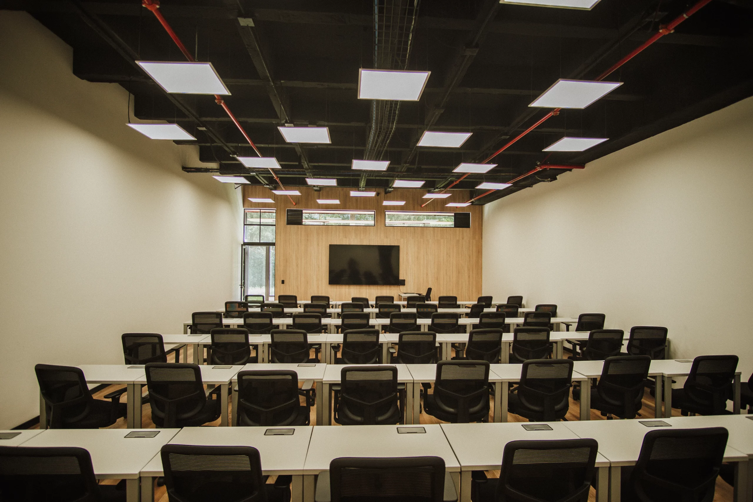 Salón con escritorios y pantalla